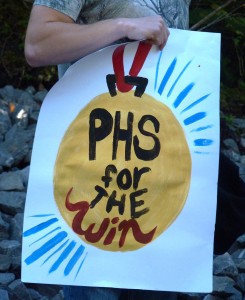 A fan holds a sign cheering on Petersburg High School during Saturday's cross-country meet.